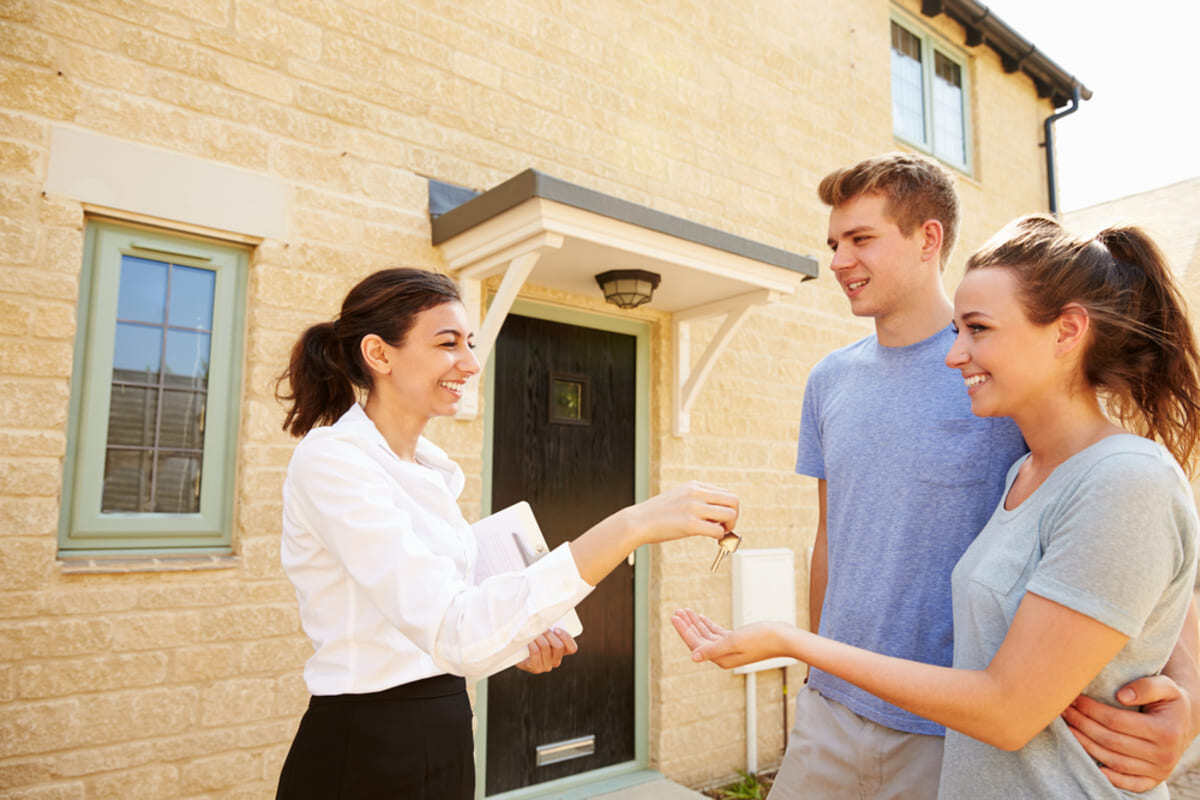 Real estate agent giving keys to new tenants.